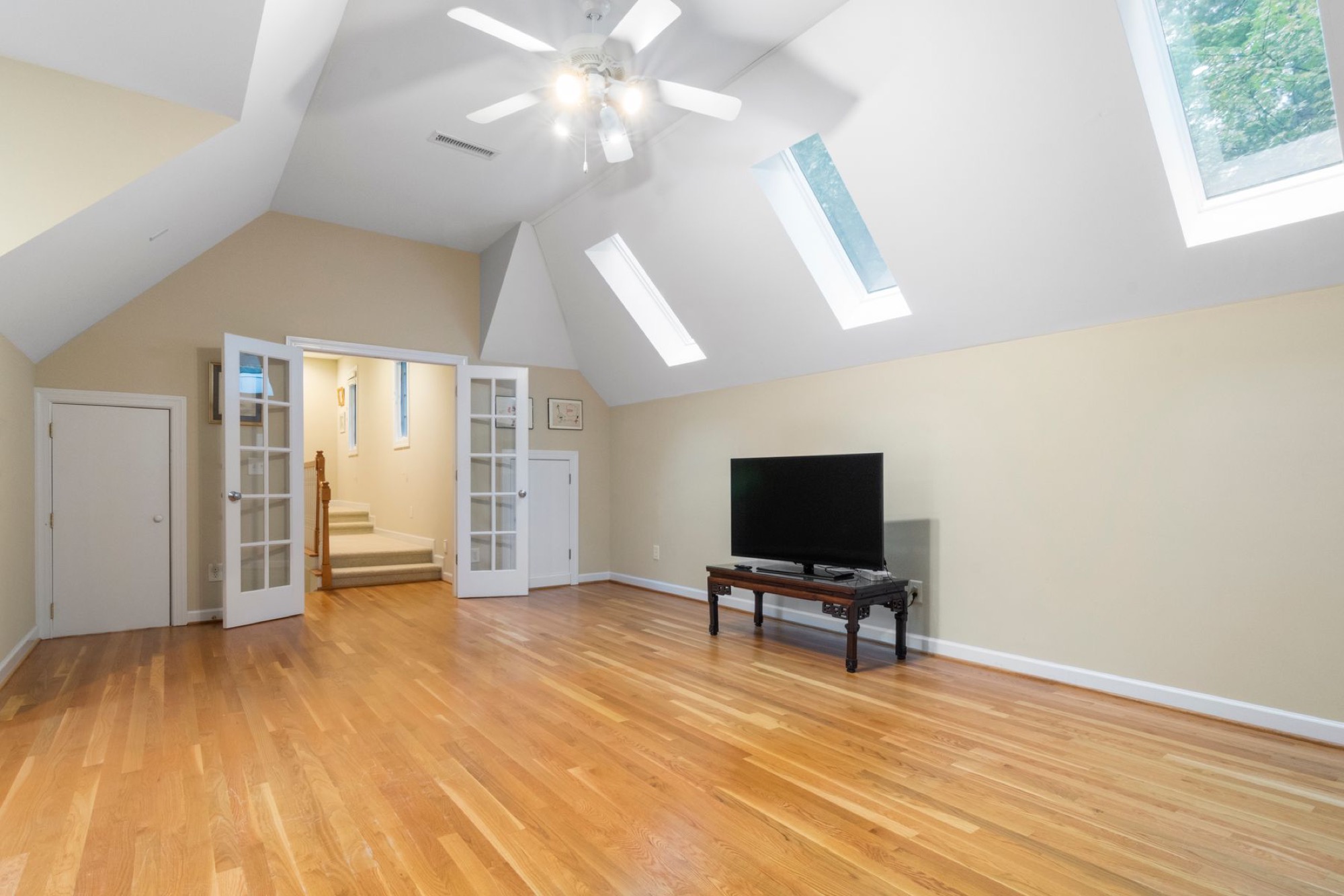 Finished bonus room with sloped ceilings, skylights, and ceiling fan, cooling a bonus room without high energy bills