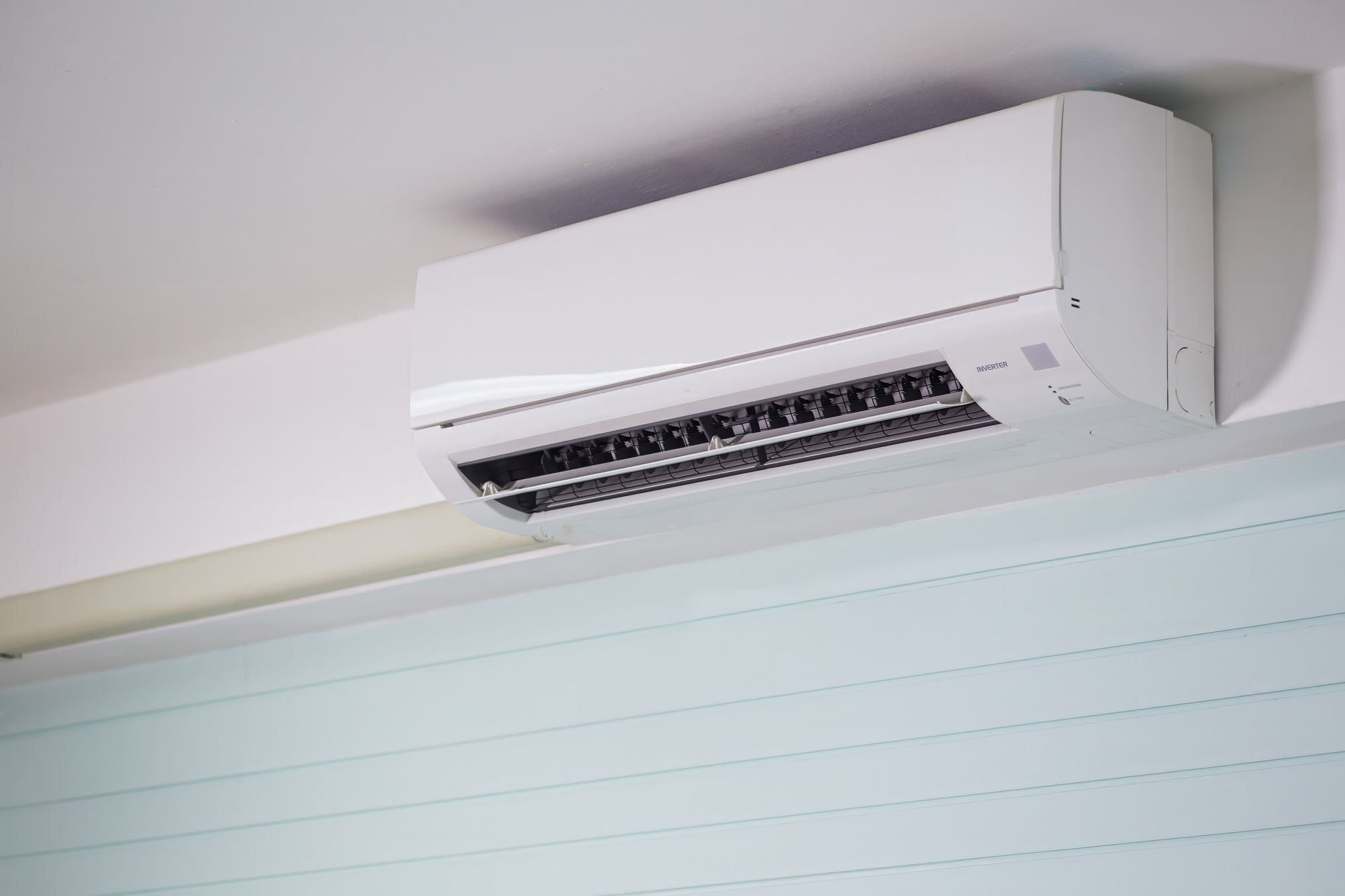 Wall-mounted mini split inverter unit installed near ceiling, a way to cool a garage without central air